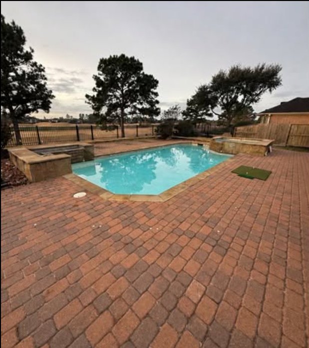 Pool deck before renovation, showing worn red brick pavers
