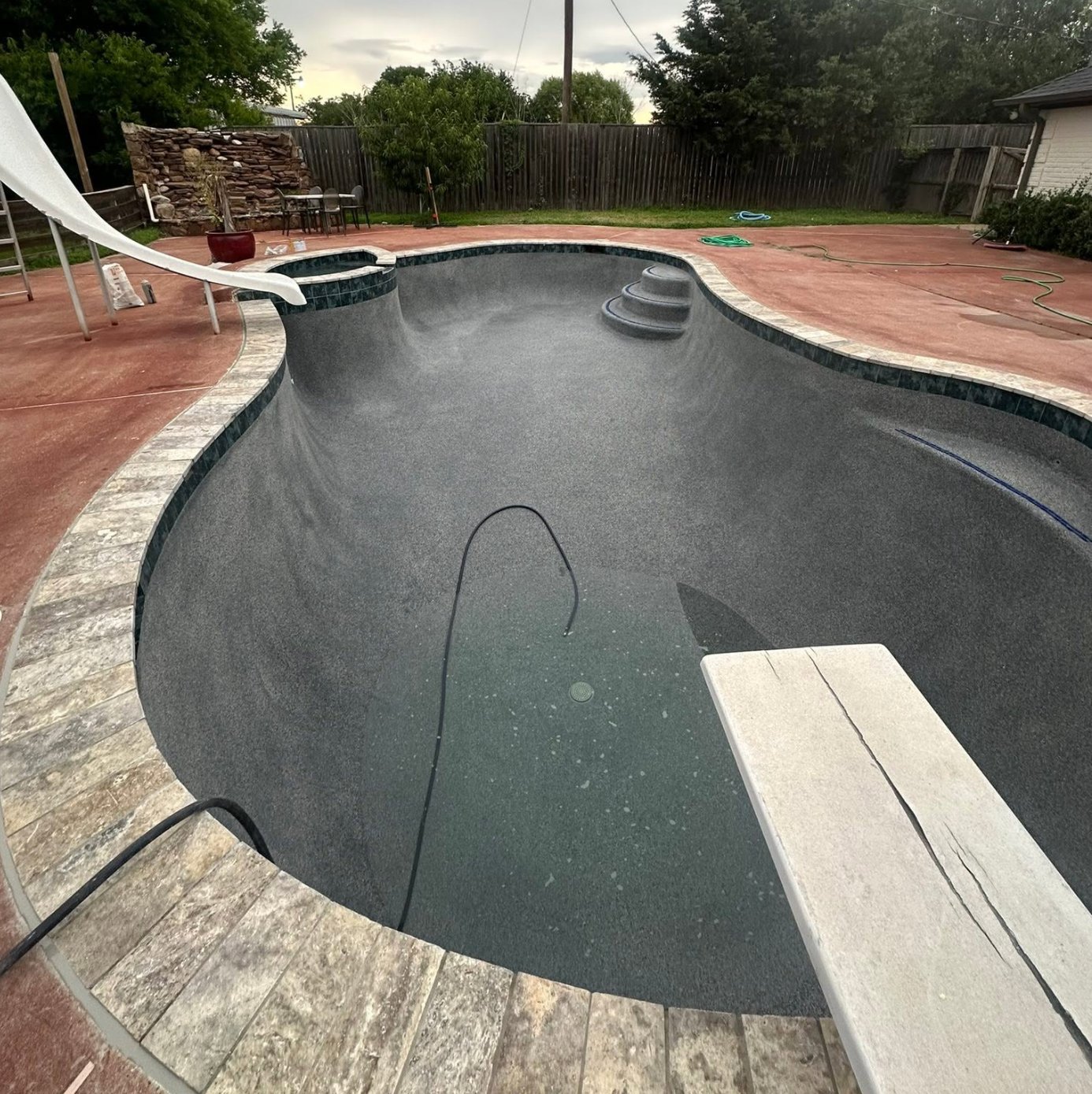 Same pool with a new dark textured finish after resurfacing