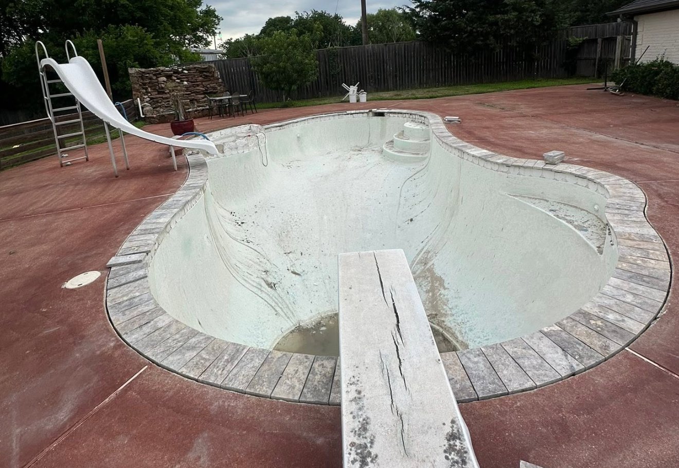 Pool with worn, discolored interior finish before resurfacing