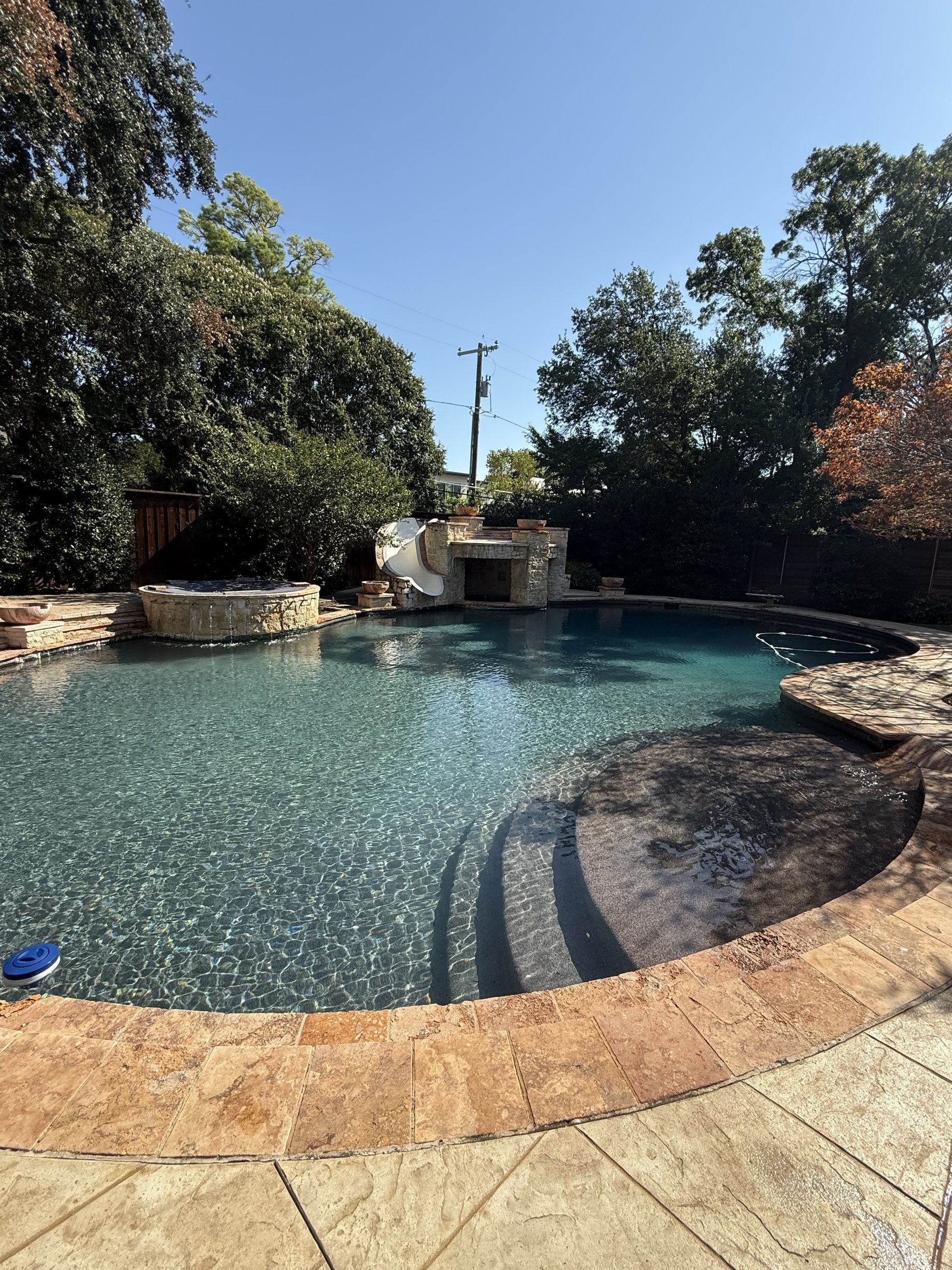 Same backyard pool with crystal clear blue water after professional service