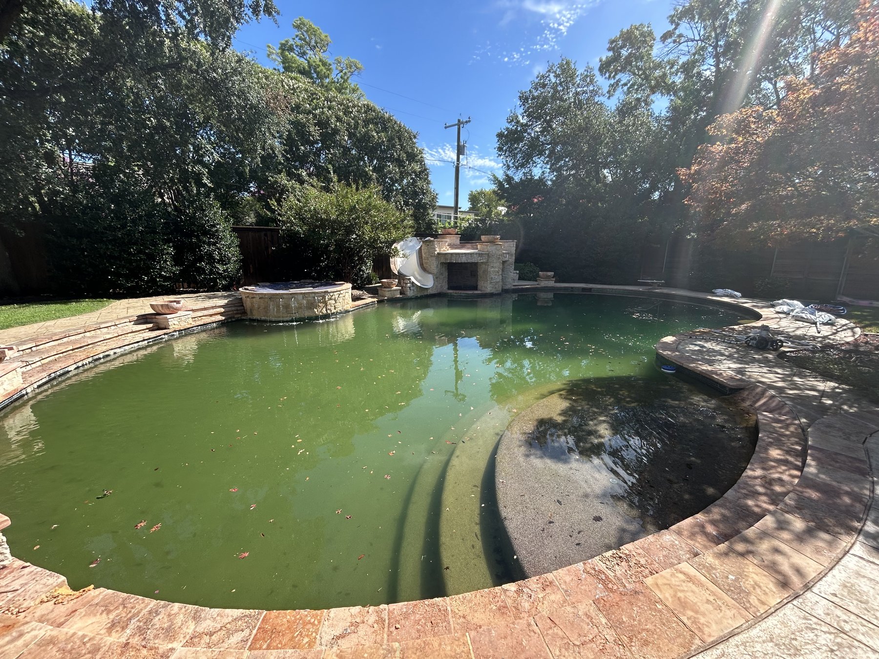 Backyard pool with green algae water before professional cleaning and service