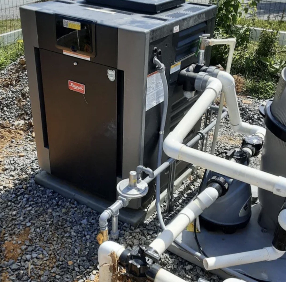 Raypak gas pool heater installed and plumbed on an equipment pad